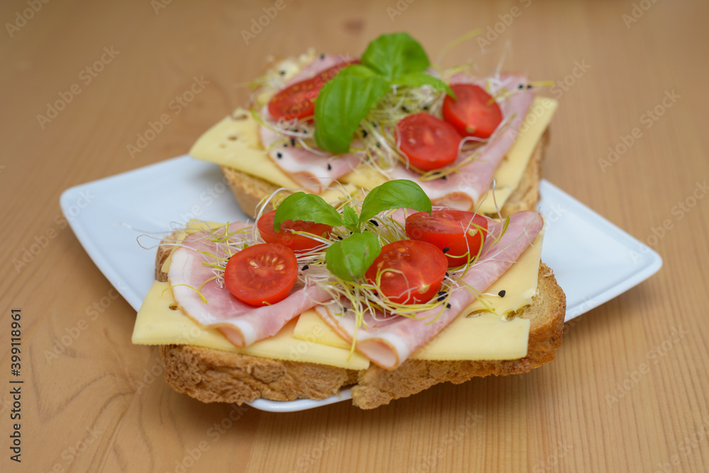 smaczne domowe tosty z serem, szynką i pomidorami oraz kiełki