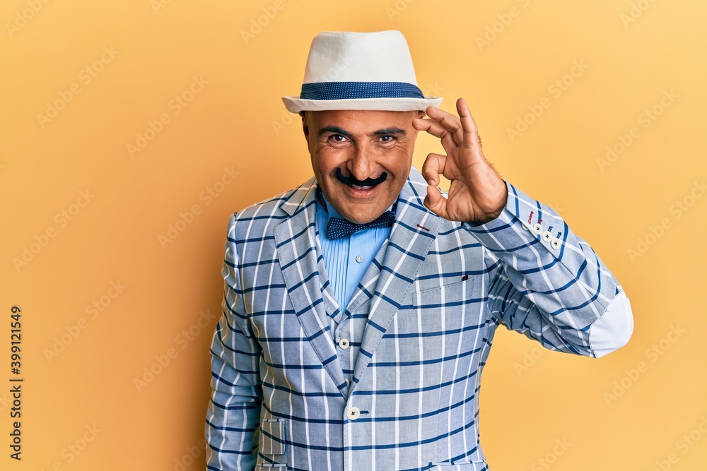 Mature middle east man with mustache wearing vintage and elegant fashion style smiling positive doing ok sign with hand and fingers. successful expression.
