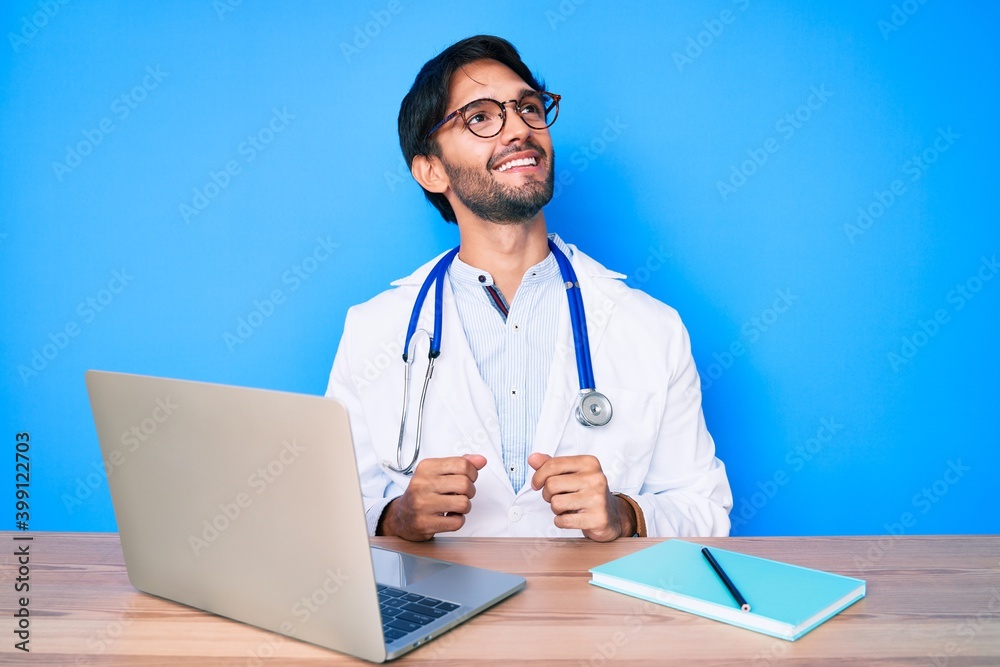 Handsome hispanic man wearing doctor uniform working at the clinic looking to side, relax profile pose with natural face and confident smile. Handsome hispanic man wearing doctor uniform working at the clinic looking to side, relax profile pose with natural face and confident smile.