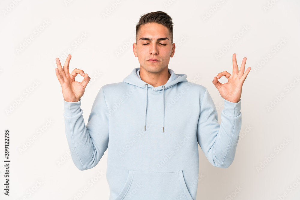 Young caucasian handsome man isolated relaxes after hard working day, she is performing yoga. Young caucasian handsome man isolated relaxes after hard working day, she is performing yoga.