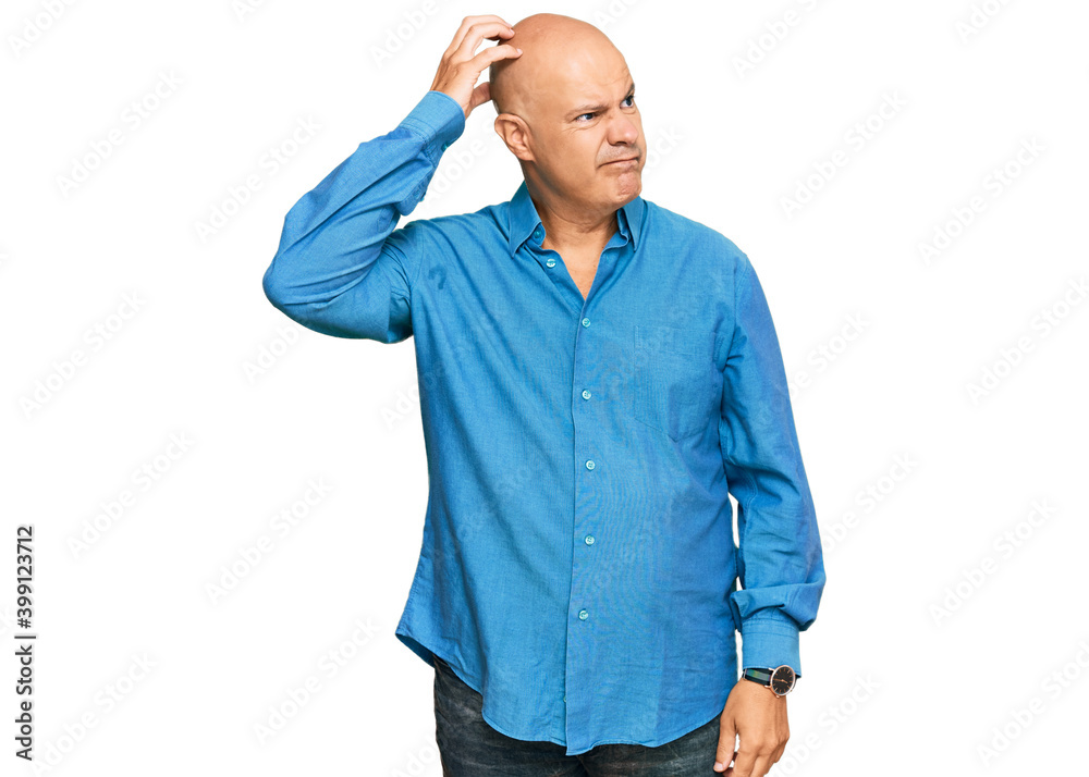 Middle age bald man wearing casual clothes confuse and wondering about question. uncertain with doubt, thinking with hand on head. pensive concept. Middle age bald man wearing casual clothes confuse and wondering about question. uncertain with doubt, thinking with hand on head. pensive concept.