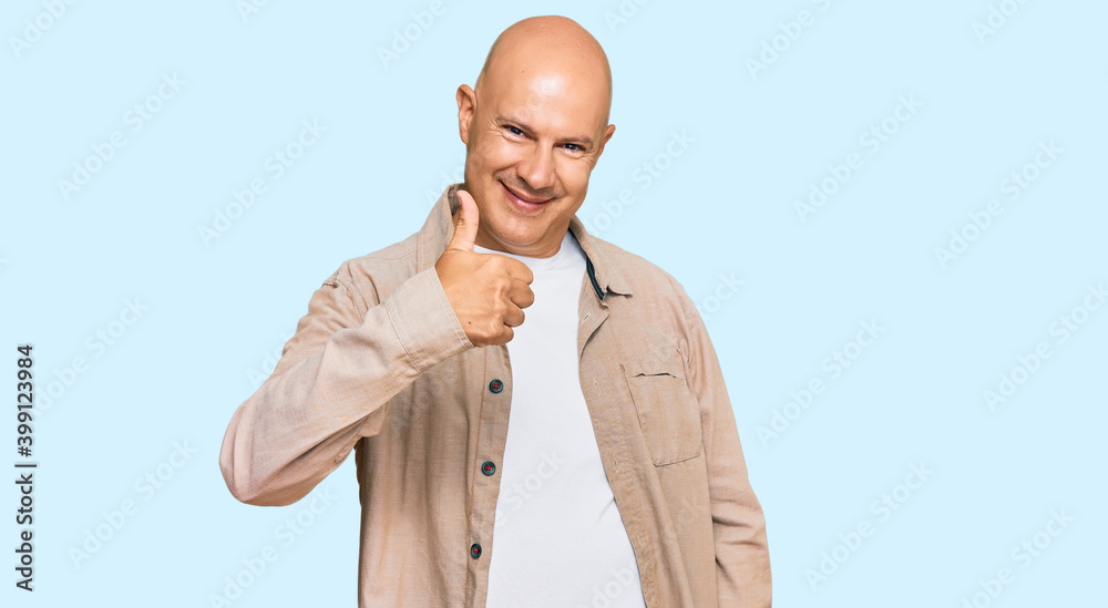 Middle age bald man wearing casual clothes doing happy thumbs up gesture with hand. approving expression looking at the camera showing success. Middle age bald man wearing casual clothes doing happy thumbs up gesture with hand. approving expression looking at the camera showing success.