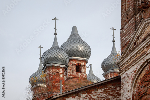 A ruined, abandoned old rural temple. Domes with broken crosses and trees growing on them. photo