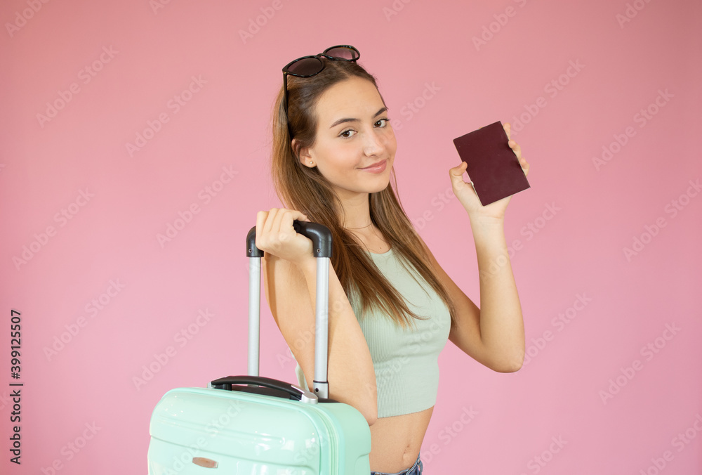 Image of excited young pretty woman tourist posing isolated over pink wall background with suitcase holding passport with tickets make winner gesture. Image of excited young pretty woman tourist posing isolated over pink wall background with suitcase holding passport with tickets make winner gesture.