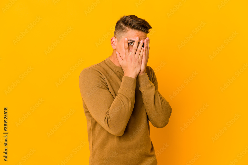 Young handsome caucasian man isolated blink through fingers frightened and nervous. Young handsome caucasian man isolated blink through fingers frightened and nervous.