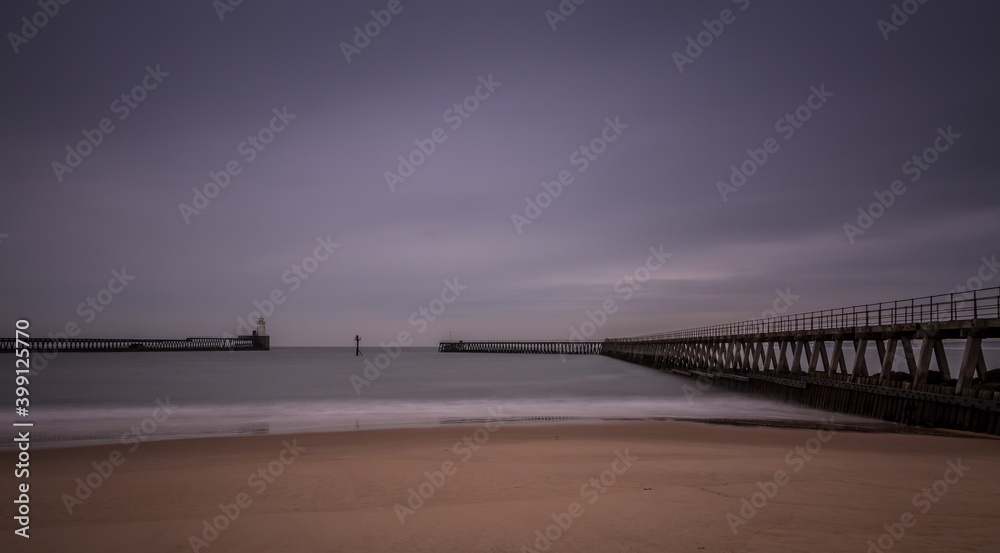 Fototapeta premium Morning at Blyth beach in Northumberland, England, with the old wooden Pier stretching out to the North Sea