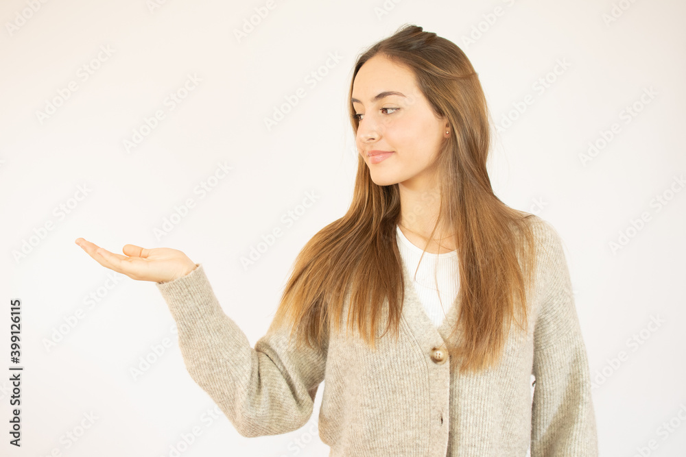 Portrait of a smiling caucasian young girl holding copy space on her palm isolated over white background Portrait of a smiling caucasian young girl holding copy space on her palm isolated over white background