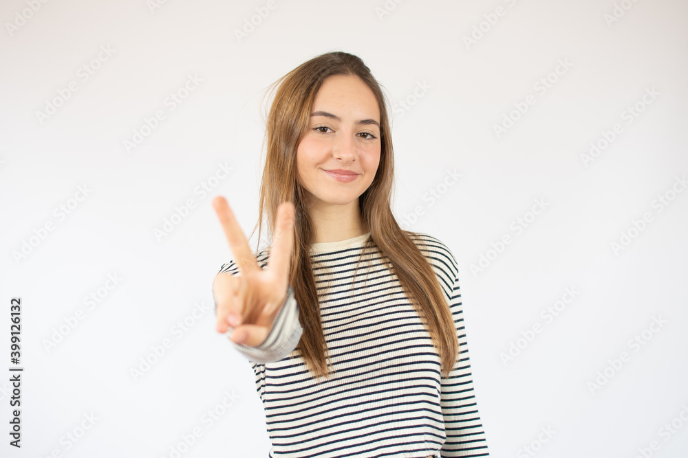 Portrait of cheerful young woman showing two fingers or victory gesture, over white background Portrait of cheerful young woman showing two fingers or victory gesture, over white background