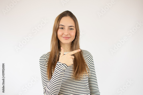 Portrait of cheerful young woman showing two fingers or victory gesture, over white background © Danko