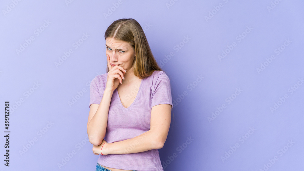 Young blonde woman isolated on purple background unhappy looking in camera with sarcastic expression. Young blonde woman isolated on purple background unhappy looking in camera with sarcastic expression.