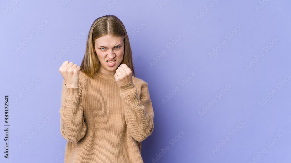 Young blonde woman isolated on purple background upset screaming with tense hands. Young blonde woman isolated on purple background upset screaming with tense hands.