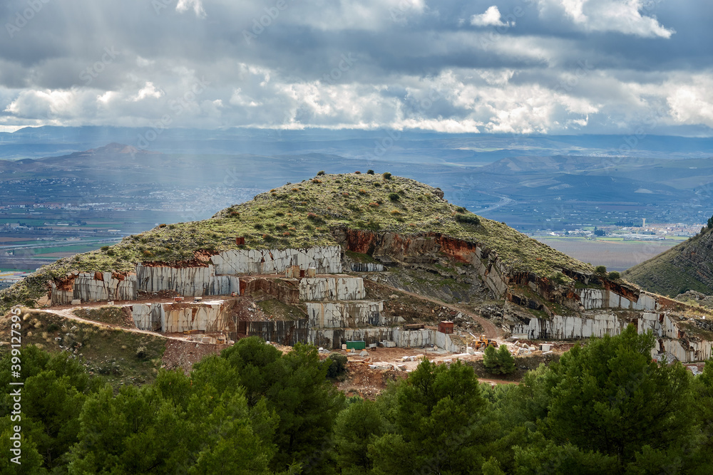 Open marble quarry on a hill with the city in the background