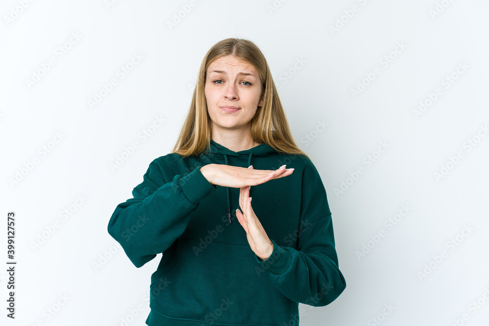 Young blonde woman isolated on white background showing a timeout gesture. Young blonde woman isolated on white background showing a timeout gesture.