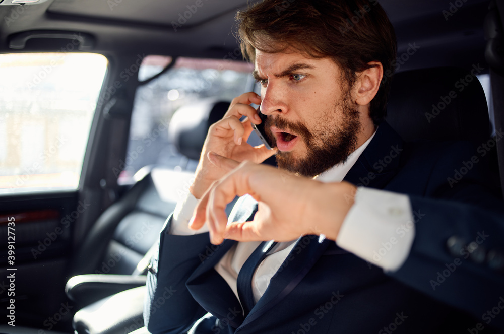a man in a suit in a car talking on the phone an official passenger