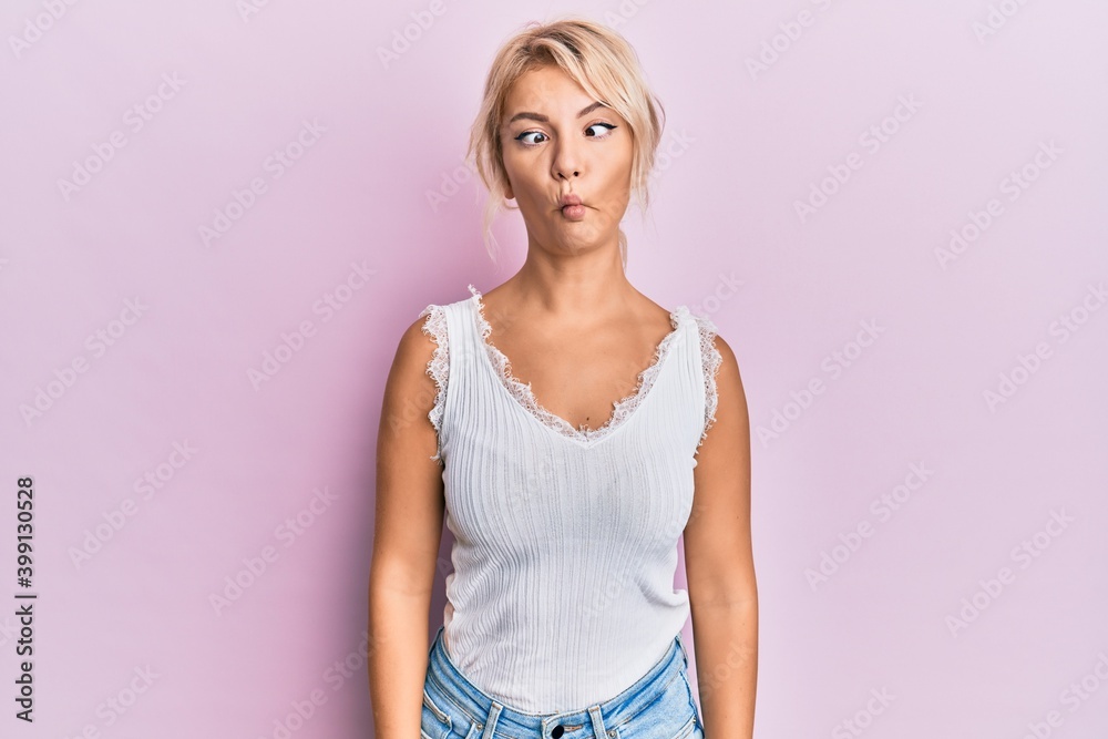 Young blonde girl wearing casual clothes making fish face with lips, crazy and comical gesture. funny expression. Young blonde girl wearing casual clothes making fish face with lips, crazy and comical gesture. funny expression.