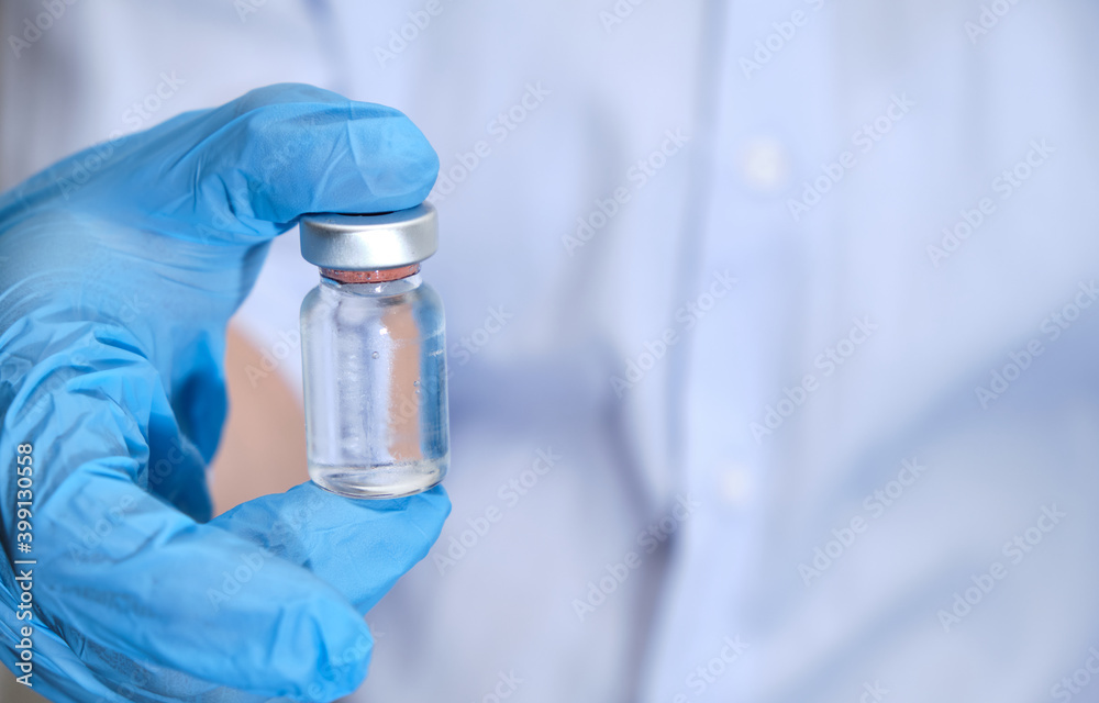 Pandemic concept, close up of scientist injecitng vaccine. Doctor, nurse, scientist hand in blue gloves holding flu, measles, coronavirus, covid-19 vaccine disease preparing for people. Pandemic concept, close up of scientist injecitng vaccine. Doctor, nurse, scientist hand in blue gloves holding flu, measles, coronavirus, covid-19 vaccine disease preparing for people.