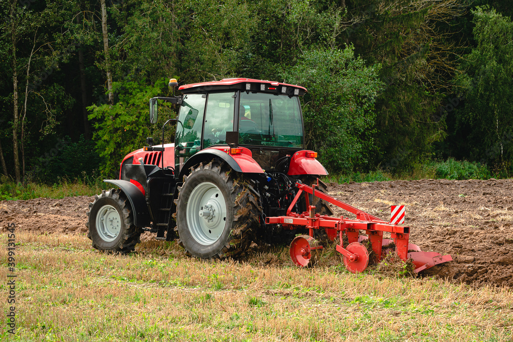 Farmer in tractor preparing land for sowing, plowing the field Farmer in tractor preparing land for sowing, plowing the field