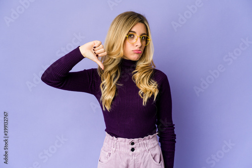 Young caucasian blonde woman showing thumb down, disappointment concept.