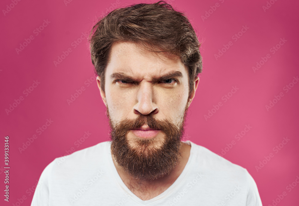 Man with bushy beard on a pink background white t-shirt cropped view Man with bushy beard on a pink background white t-shirt cropped view