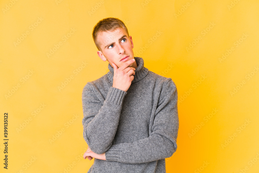 Young caucasian handsome man looking sideways with doubtful and skeptical expression.