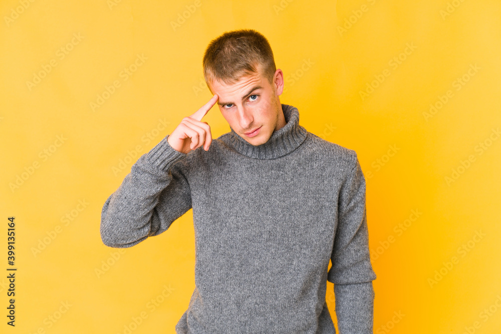 Young caucasian handsome man pointing temple with finger, thinking, focused on a task. Young caucasian handsome man pointing temple with finger, thinking, focused on a task.