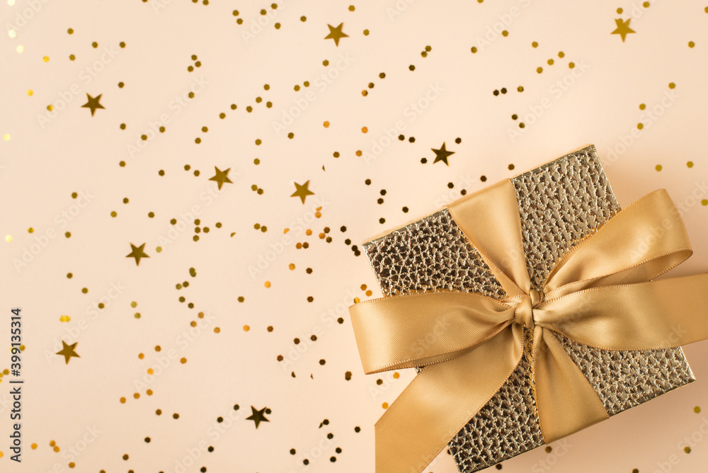 Top above close up view photo of beautiful present box with golden ribbon standing on shiny glitter table with place for header Top above close up view photo of beautiful present box with golden ribbon standing on shiny glitter table with place for header