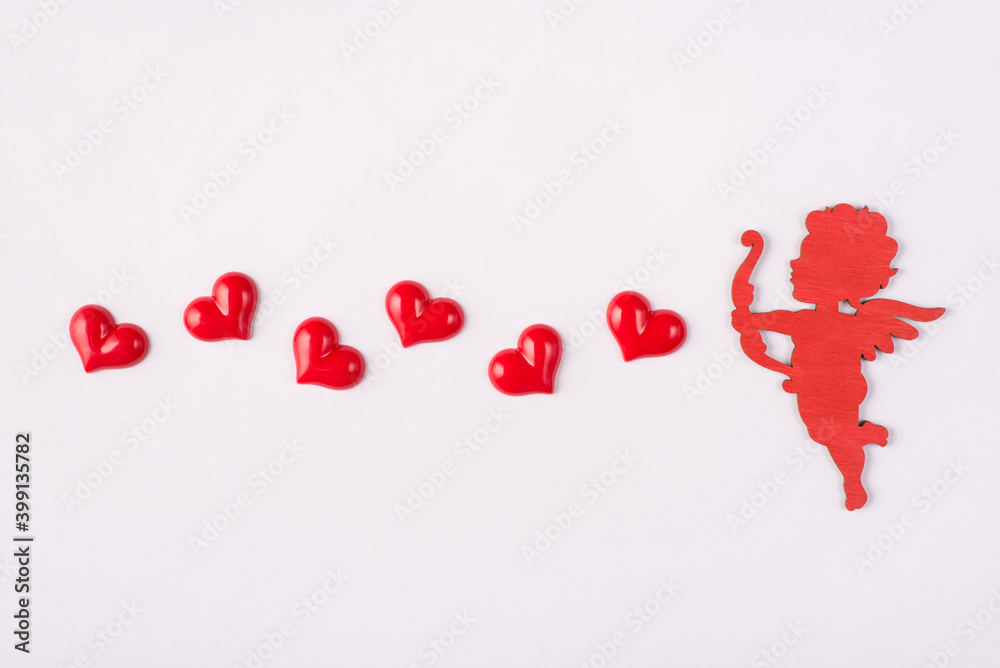 Happy saint valentines day concept. Photo of cute sweet cupid shooting with hearts isolated white background