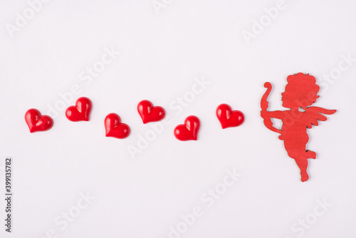 Happy saint valentines day concept. Photo of cute sweet cupid shooting with hearts isolated white background