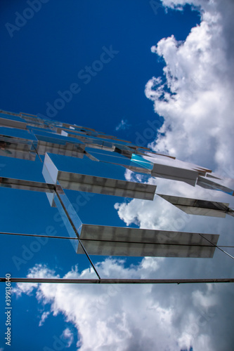 skyscraper panels reflect a clear sky with clouds