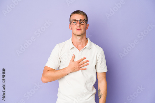 Young caucasian handsome man taking an oath, putting hand on chest.