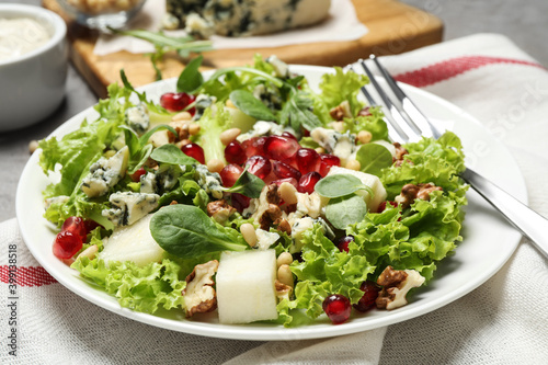 Fresh salad with pear on table, closeup