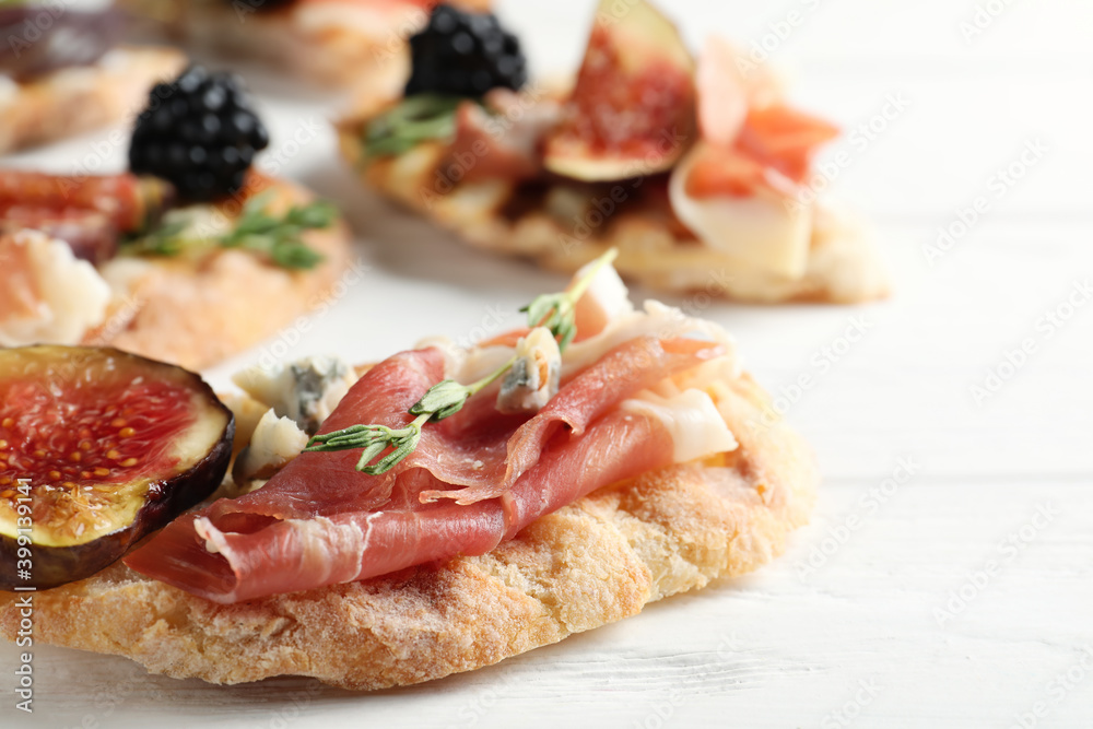 Sandwich with ripe figs and prosciutto served on white wooden table, closeup Sandwich with ripe figs and prosciutto served on white wooden table, closeup