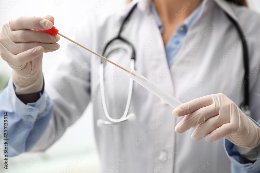 Doctor holding buccal cotton swab and tube for DNA test in clinic, closeup Doctor holding buccal cotton swab and tube for DNA test in clinic, closeup