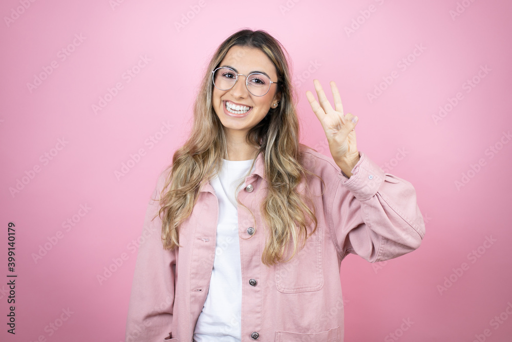 Young beautiful blonde woman with long hair standing over pink background showing and pointing up with fingers number three while smiling confident and happy Young beautiful blonde woman with long hair standing over pink background showing and pointing up with fingers number three while smiling confident and happy