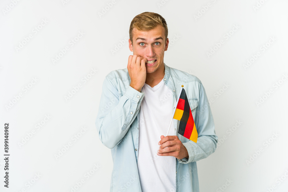Young caucasian man holding a german flag isolated on white background Young caucasian man holding a german flag isolated on white background