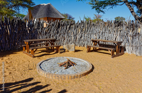 Fire pit inside wooden stockade and benches