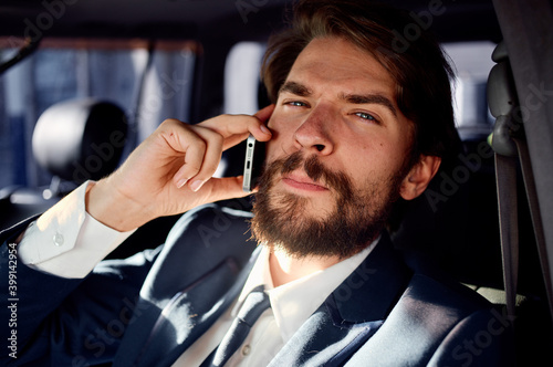 Virgo man talking on the phone while driving a car in the salon