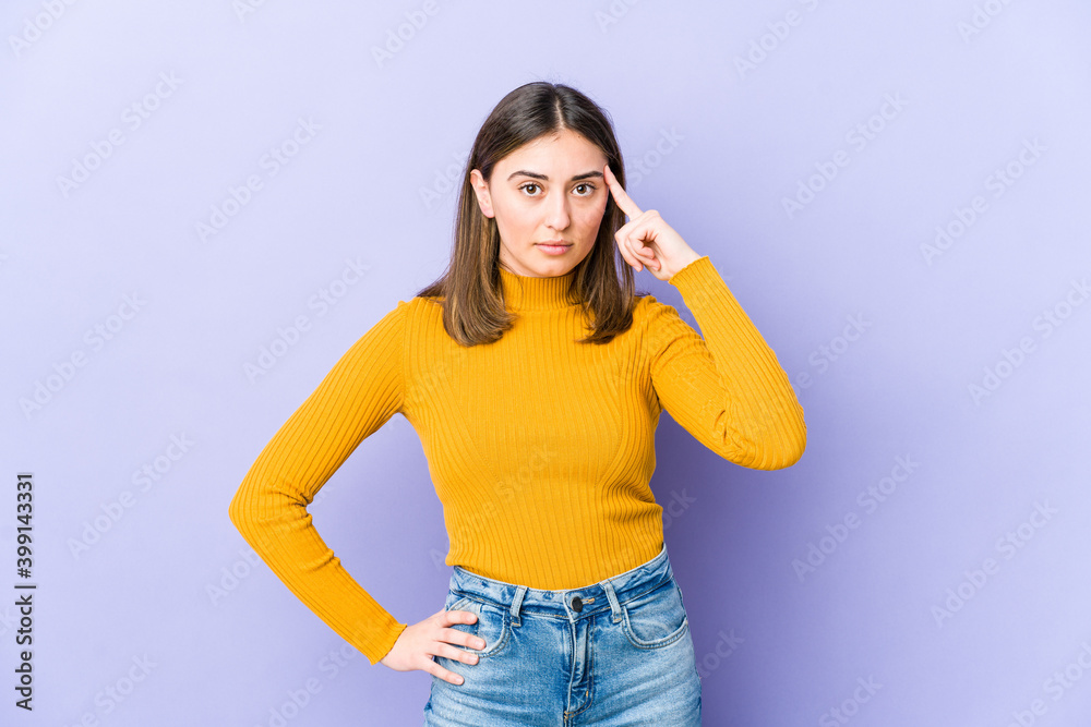Young caucasian woman pointing temple with finger, thinking, focused on a task. Young caucasian woman pointing temple with finger, thinking, focused on a task.