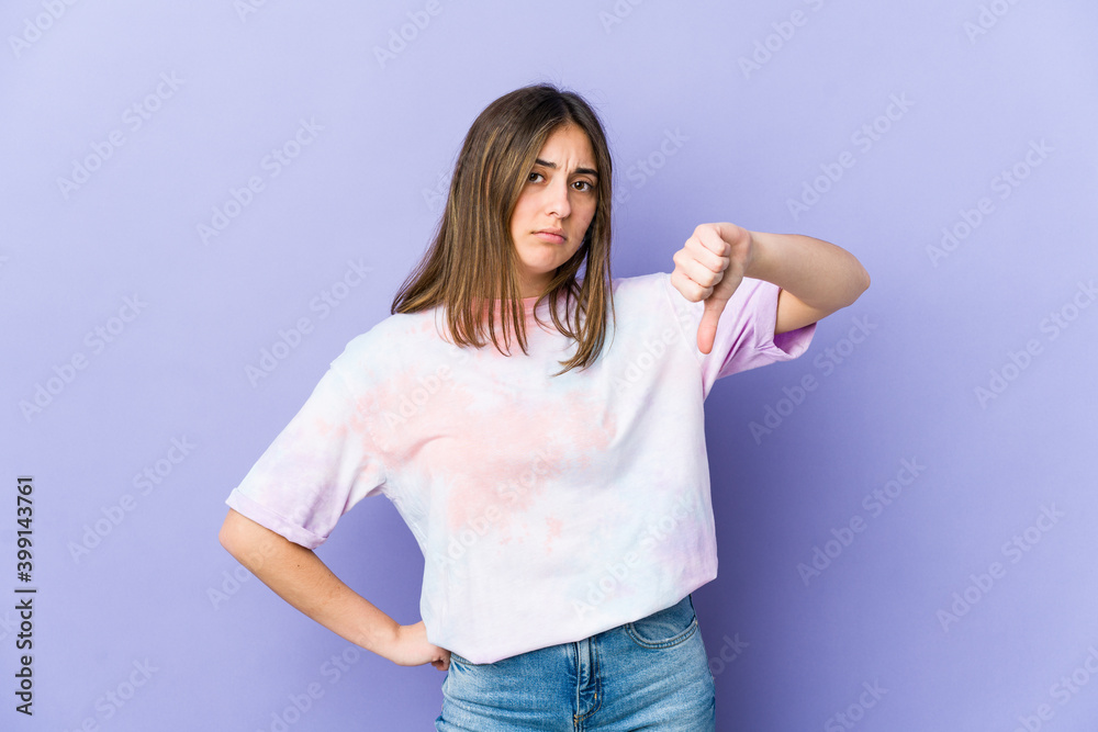 Young caucasian woman showing a dislike gesture, thumbs down. Disagreement concept. Young caucasian woman showing a dislike gesture, thumbs down. Disagreement concept.
