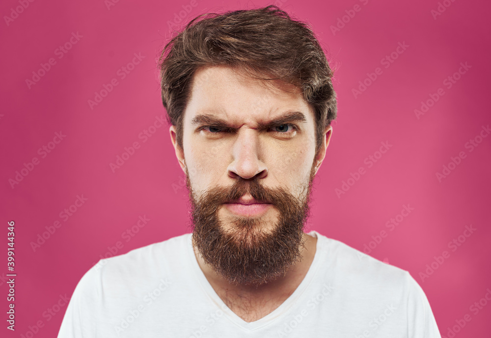 Man with bushy beard on a pink background white t-shirt cropped view Man with bushy beard on a pink background white t-shirt cropped view