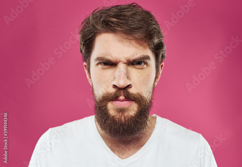 Man with bushy beard on a pink background white t-shirt cropped view © SHOTPRIME STUDIO