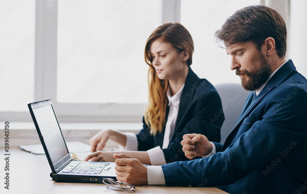 Work colleagues in suits working desk laptop office managers team Work colleagues in suits working desk laptop office managers team