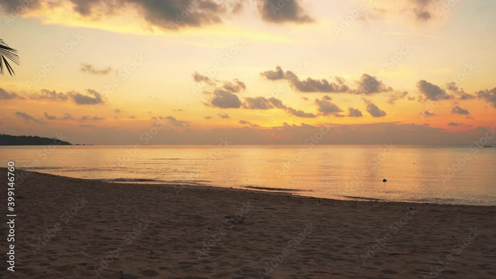 An elderly couple walking along the shore of a sandy beach along the sea at sunrise An elderly couple walking along the shore of a sandy beach along the sea at sunrise