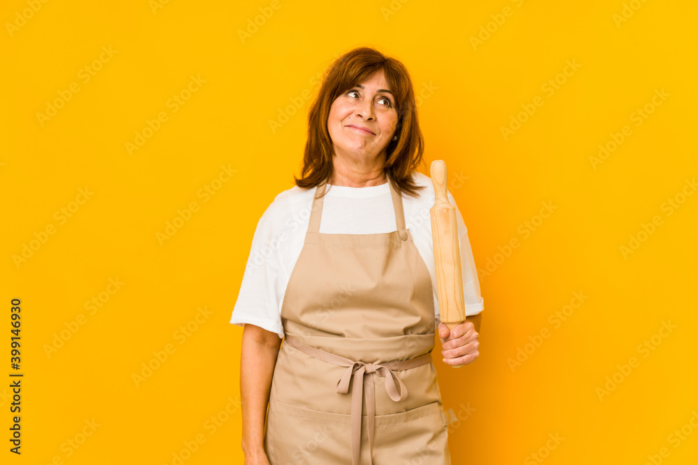 Middle age caucasian cook woman holding a roller isolated dreaming of achieving goals and purposes Middle age caucasian cook woman holding a roller isolated dreaming of achieving goals and purposes