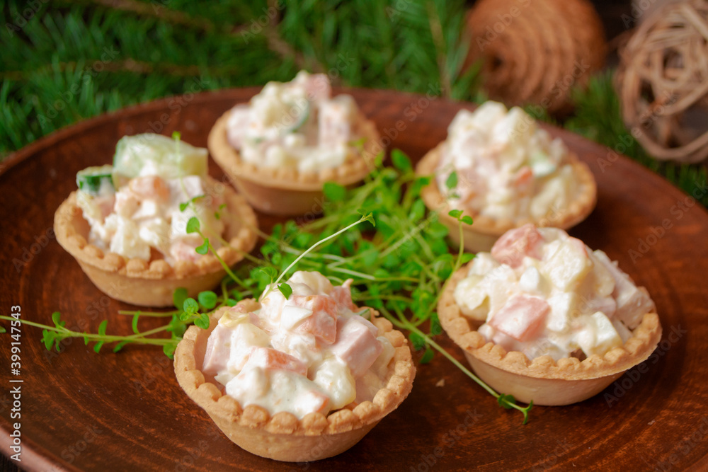 Christmas salad with vegetables in tartlets on a brown background