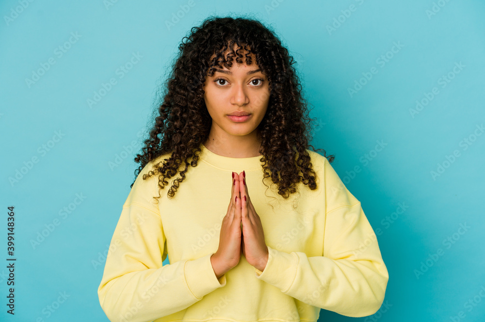 Young african american afro woman isolated praying, showing devotion, religious person looking for divine inspiration. Young african american afro woman isolated praying, showing devotion, religious person looking for divine inspiration.