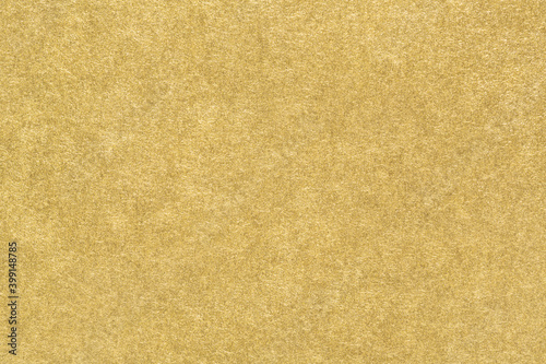 Gold paper texture. Smooth matte golden foil abstract background. Close-up.
