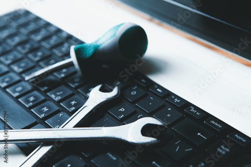 Electronic technical support concept. Wrenches on a computer keyboard. photo