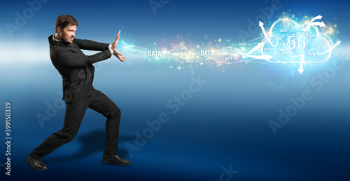 businessman firing data like a superpower into a 5G cloud on blue background photo