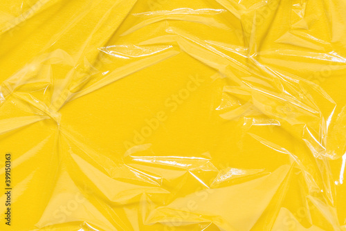Wrinkled cling film, plastic texture, vinyl background. Yellow overlay for mockup. Abstract, art design layout.